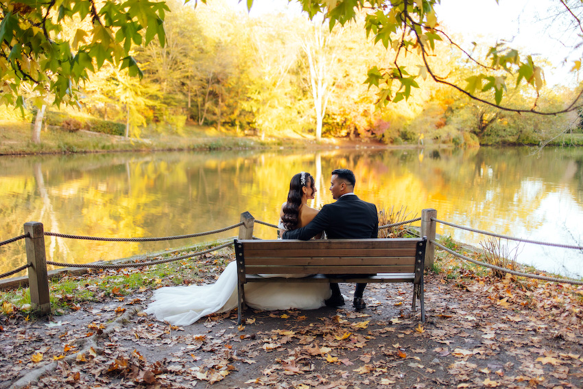 Zeynep’in gelinliği, kasrın taş duvarları arasında bir masal gibi süzülürken Ali’nin bakışlarında tek bir cümle vardı: “İyi ki.” Abartısız, gösterişsiz ama çok derin… İşte gerçek aşk tam da böyle bir şeydi. Poz vermek hiç gerekmedi; onlar yan yana durdukça anlar kendiliğinden oluştu. Gülüşler içtendi, dokunuşlar sakindi, her karede güven vardı. Hidiv Kasrı’ndaki çekim, hikâyenin ağırbaşlı başlangıcı gibiydi. Ardından Atatürk Arboretumu’na doğru yola çıktık. Sonbaharın sarıdan altına dönen renkleri, göl kenarında sessizce süzülen kuğular, yaprakların altında kalan patikalar… Doğa, sanki bu aşka özel hazırlanmıştı. Zeynep ve Ali yürüdükçe ışık onları takip etti, ağaçlar başlarını eğip bu mutluluğa tanıklık etti. Atatürk Arboretumu’nda çekilen her karede biraz huzur, biraz heyecan, çokça sevgi vardı. Gelinliğin etekleri yapraklara karıştı, kahkahalar dalların arasından yankılandı. Kimse acele etmedi. Çünkü bazı anlar çabuk geçmesin diye yavaş yaşanır. Benim için düğün fotoğrafçılığı, sadece güzel kareler yakalamak değil; o günün ruhunu, çiftlerin birbirine baktığında hissettiklerini yıllar sonrasına taşıyabilmek. Zeynep ve Ali çekim sonunda yanımdan ayrılırken yüzlerinde aynı ifade vardı: Hafiflemiş, mutlu ve tamamlanmış… İstanbul’da düğün fotoğrafı çektirmek isteyen her çift için Hidiv Kasrı ve Atatürk Arboretumu hâlâ en özel duraklardan. Ama asıl güzellik, oraya götürdüğünüz hikâyede saklı. Doğru ışık, doğru an ve samimi bir bağ bir araya geldiğinde ortaya çıkan şey, sadece fotoğraf değil; bir hatıradır.